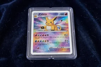 Carte Pokémon Celebi star en excellent état conservée dans une protection rigide transparente posée sur du velours bleu marine